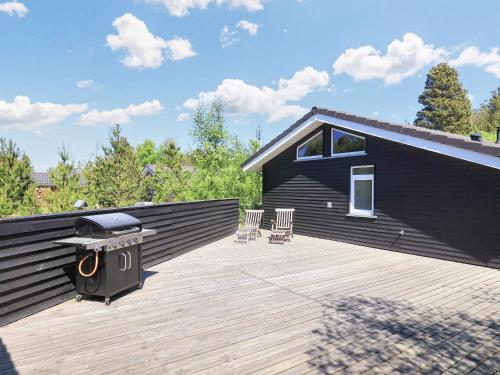 una casa negra con una parrilla en la cubierta en 6 person holiday home in lb k, en Ålbæk