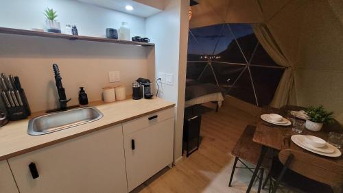 una cucina con lavandino e tavolo in una stanza di White Camel a Kanab