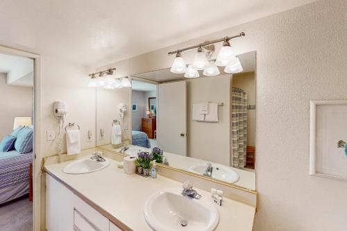 a bathroom with two sinks and a large mirror at Lake Daze at Wapato Point in Manson