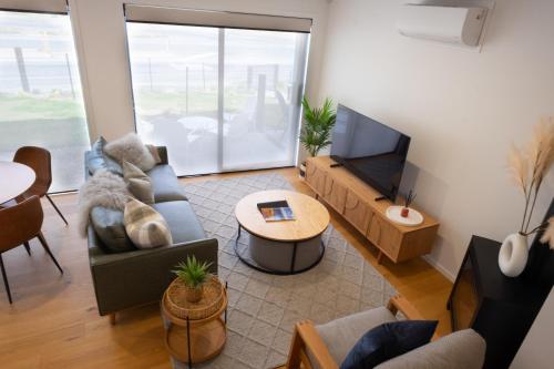a living room with a couch and a tv at Alpine Junction Townhouse Apartments, Lodge & Hotel in Wanaka