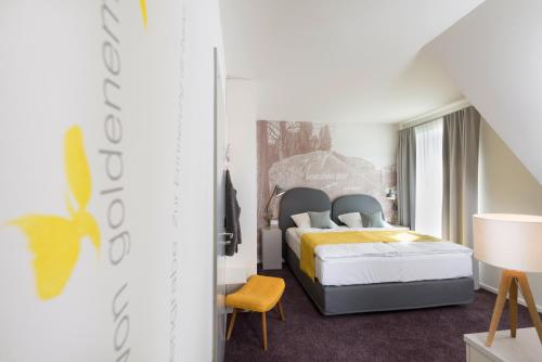 a hotel room with a bed and a chair at Schmucke Witwe in Bispingen