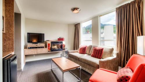 a living room with a couch and a tv at Adara Hotel in Whistler