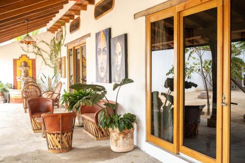 a porch with chairs and potted plants and a glass door at El MURO MAJAHUA RETREAT CENTER in La Majahua