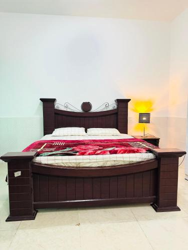 a bedroom with a large bed with a red blanket at Global Haven Retreat in Ajman