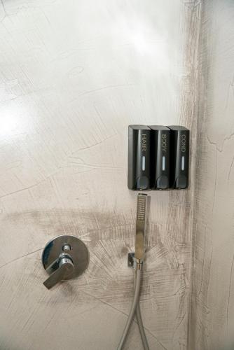 a wall with a faucet next to a sink at Hotel Pernoca in Durrës