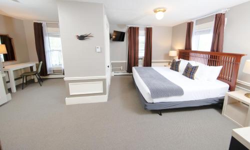 a hotel room with a bed and a desk at The New London Inn in New London