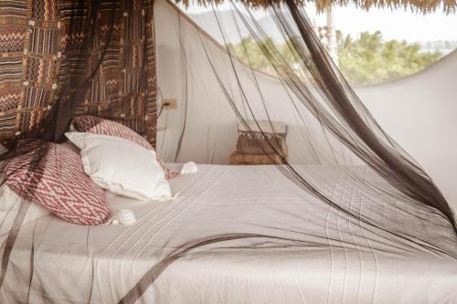 a bed in a room with a mosquito net at El MURO MAJAHUA RETREAT CENTER in La Majahua