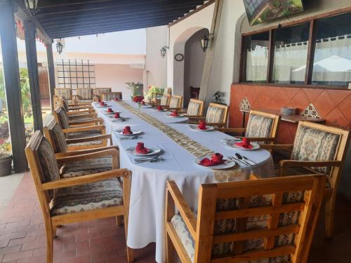a long dining room with a long table and chairs at Villas Arqueologicas Cholula in Cholula