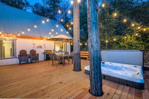 a deck with a table and chairs and lights at Lakeview Lodge w/ Boat slip, hot tub, lake views in Bass Lake