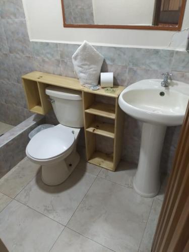 a bathroom with a toilet and a sink at Hotel Cuencano Hogar in Cuenca