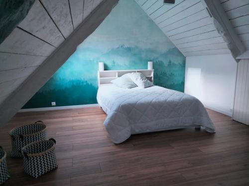 une chambre avec un grand lit dans un grenier dans l'établissement Gîte 3 chambres en bord de Rance, à La Ville-ès-Nonais