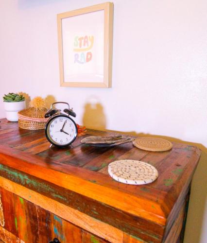 an alarm clock sitting on top of a wooden dresser at Luxurious Bohemian Bungalow in Lincolnville - Mins from Downtown! in Saint Augustine
