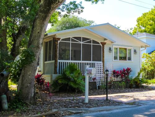 a small white house with a large window at Luxurious Bohemian Bungalow in Lincolnville - Mins from Downtown! in Saint Augustine