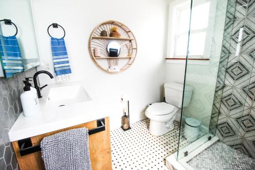a bathroom with a toilet and a glass shower at Luxurious Bohemian Bungalow in Lincolnville - Mins from Downtown! in Saint Augustine