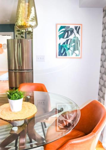 a dining room table with orange chairs and a glass table at Luxurious Bohemian Bungalow in Lincolnville - Mins from Downtown! in Saint Augustine