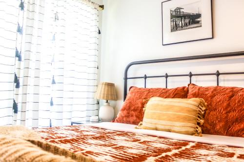 a bedroom with a bed with orange pillows at Luxurious Bohemian Bungalow in Lincolnville - Mins from Downtown! in Saint Augustine