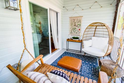 a porch with a swing and a chair at Luxurious Bohemian Bungalow in Lincolnville - Mins from Downtown! in Saint Augustine