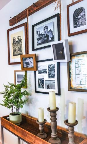 a gallery wall with pictures and candles on a table at Luxurious Bohemian Bungalow in Lincolnville - Mins from Downtown! in Saint Augustine