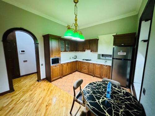 a kitchen with wooden cabinets and a black refrigerator at View of Baku Boulevard apartment by Bea Paradise in Baku