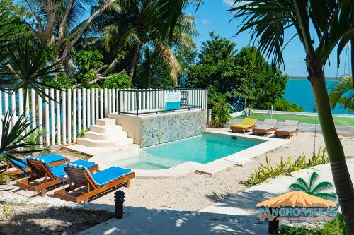 a swimming pool with lounge chairs and a swimming poolvisor at Hotel Pancho Villas Bacalar - Gratis Renta Kayyaks in Bacalar