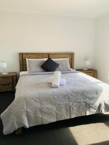 a bed with a teddy bear sitting on top of it at Nevid Family Home in Merbein South