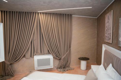 a bedroom with a bed and a window with curtains at Hotel Pernoca in Durrës