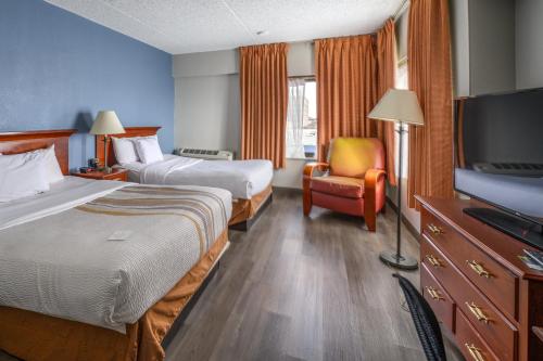 um quarto de hotel com duas camas e uma televisão de ecrã plano em La Quinta by Wyndham New Haven em New Haven