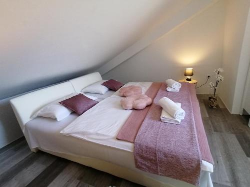 a white bed with towels and stuffed animals on it at Villa Cesarica Novalja in Novalja