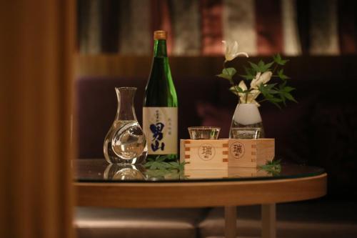 a table with a bottle of wine and two glasses at HOTEL Miz in Rifu