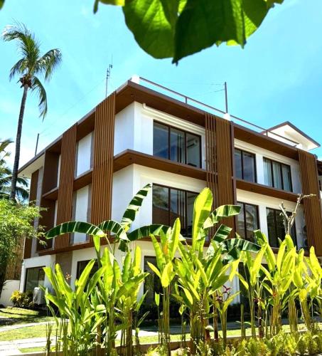 a building with a palm tree in front of it at Siargao Island Villas in General Luna