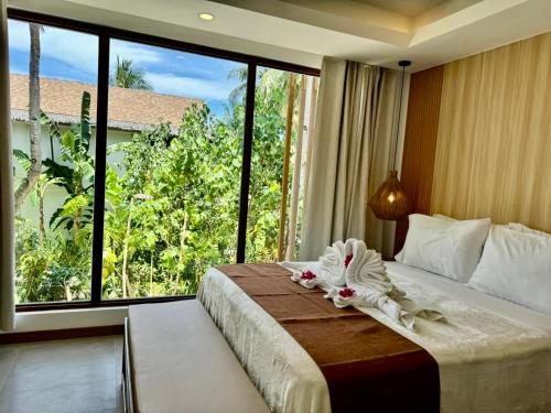 a bedroom with a bed with a large window at Siargao Island Villas in General Luna