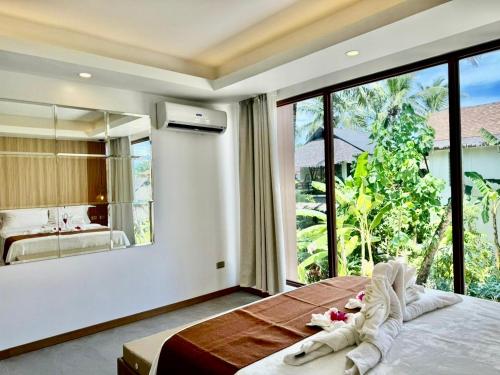a bedroom with a large window and a large bed at Siargao Island Villas in General Luna