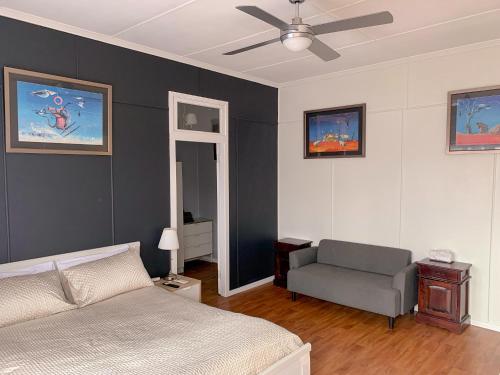 a bedroom with a bed and a chair and a ceiling fan at West End Studio 5 in Brisbane