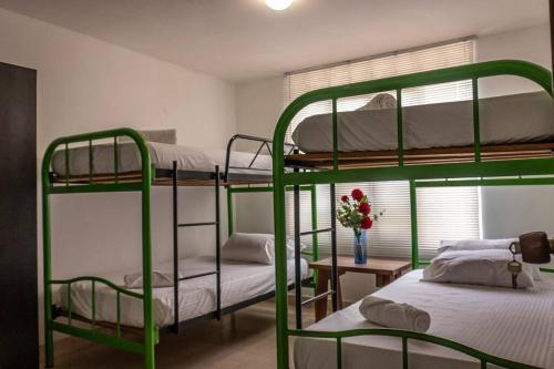 a room with two bunk beds and a table with flowers at Malejad in Zanjón Hondo