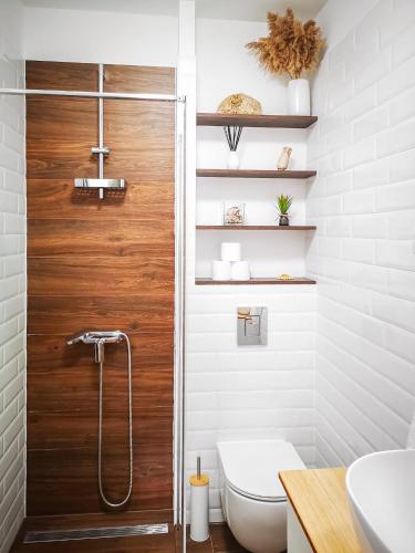 a bathroom with a wooden shower door and a toilet at The Golden View Apartment in Split