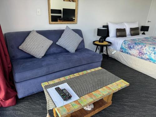 un soggiorno con divano blu e letto di DELBROOK POINT COZY-STUDIO a Hamilton