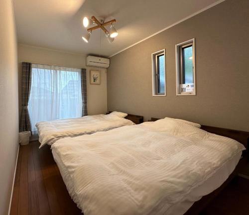 two beds in a bedroom with a ceiling fan at Saifu House - Vacation STAY 29910v in Dazaifu