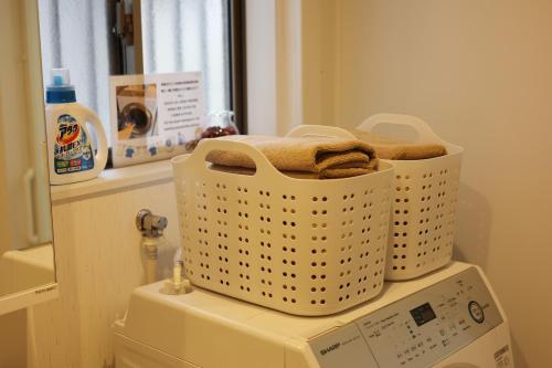 a laundry basket sitting on top of a washing machine at Saifu House - Vacation STAY 29910v in Dazaifu