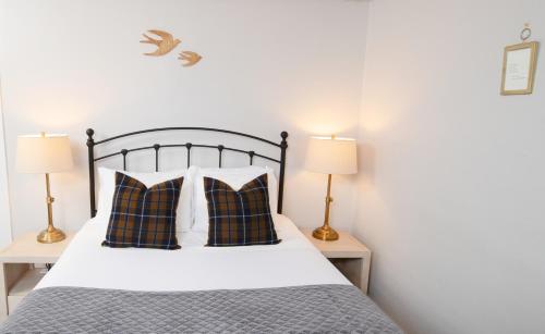 a bedroom with a bed with pillows and two lamps at The New London Inn in New London
