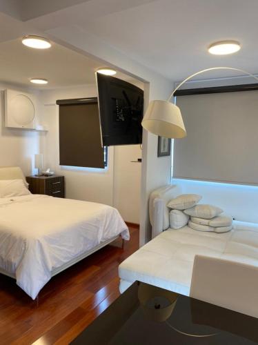 a hotel room with two beds and a flat screen tv at Suites del Valle in Mexico City