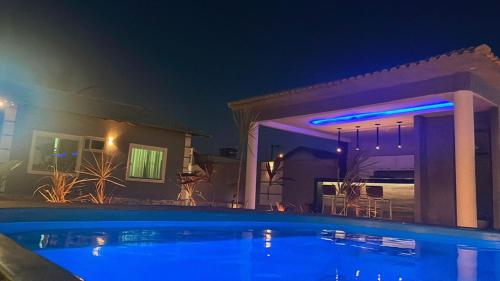 a swimming pool in front of a house at night at A Casa in Maricá