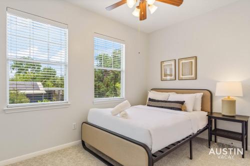 a bedroom with a bed and two windows at Perfect Central Location w Free Prkg and Cozy Beds in Austin