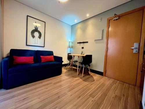 a living room with a blue couch and a table at LFlats no Hotel Stella Vega (EX-Mercury Ibirapuera) in Sao Paulo