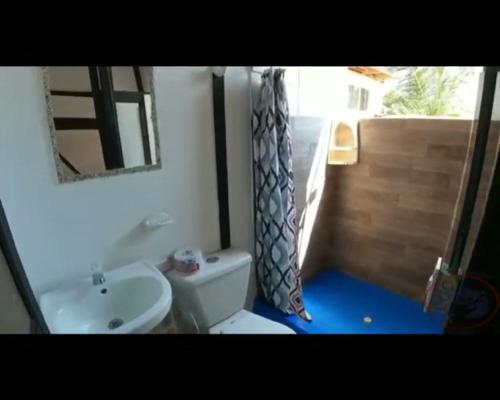 a bathroom with a sink and a toilet and a mirror at Hostal Punta Cangrejo in San Onofre