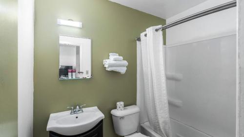 ein Badezimmer mit einem Waschbecken, einem WC und einem Spiegel in der Unterkunft Stardust Motel Inn - West Side in El Dorado