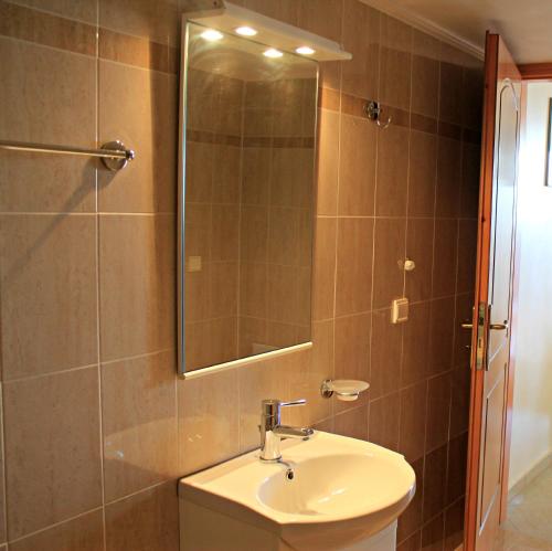 a bathroom with a sink and a mirror at Kleio Studios in Ravdhoúkha