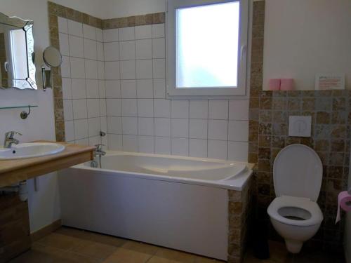 ein Badezimmer mit einer Badewanne, einem WC und einem Waschbecken in der Unterkunft Cosy villa with pool in Montbrun-des-Corbières
