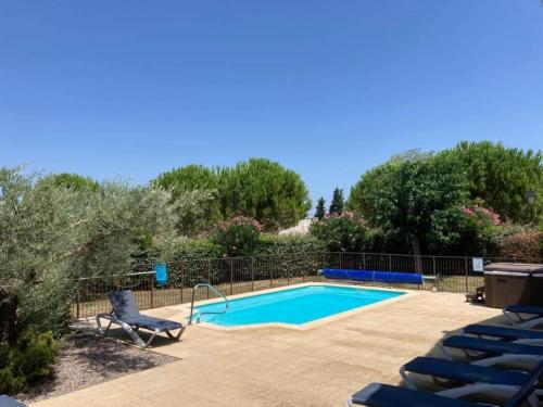 ein Pool mit blauen Stühlen neben in der Unterkunft Cosy villa with pool in Montbrun-des-Corbières