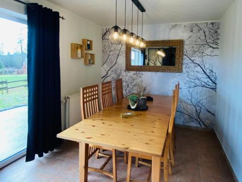 jadalnia z drewnianym stołem i lustrem w obiekcie Picture perfect Holiday Home in Sourbrodt with Garden BBQ w mieście Sourbrodt