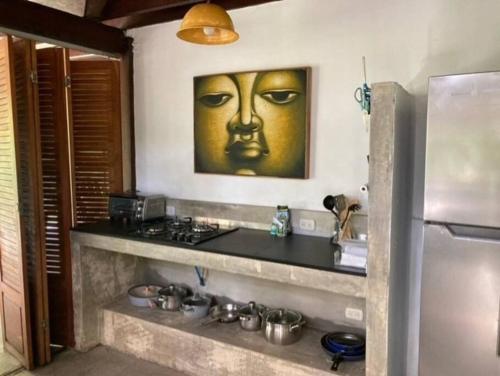 a kitchen with a painting of a face on the wall at Punta Uva Puerto Viejo Beach Front House in Punta Uva
